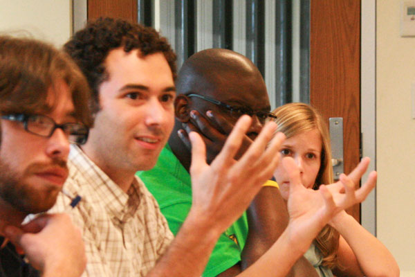 Four Diverse male and female students engage in a conversation.